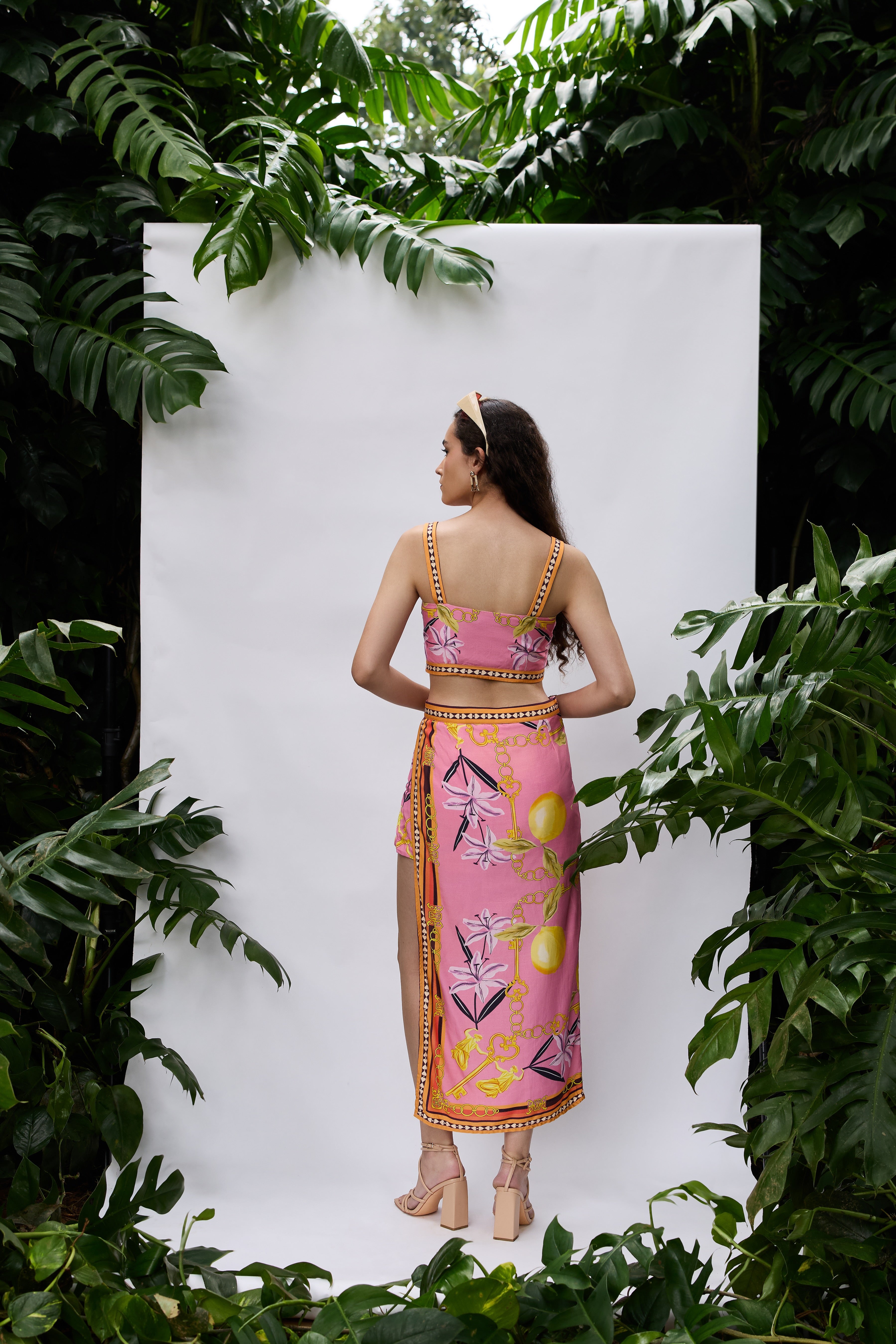 Back view of Lilly Bloom Co-ord Set — strappy crop top and high-slit skirt in pink satin