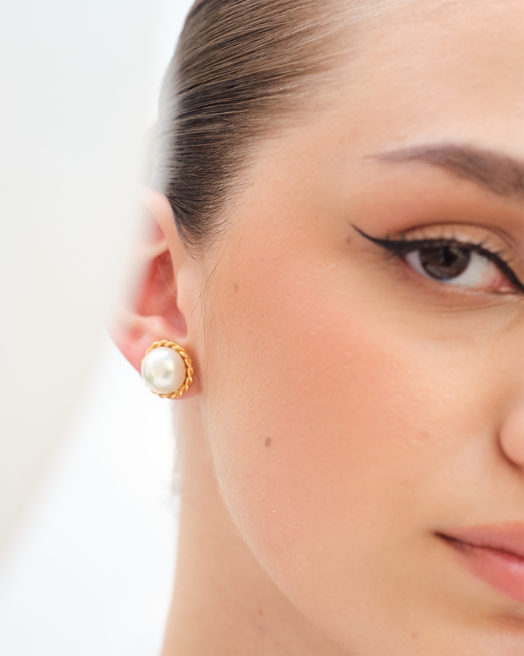 White pearl stud earrings with gold-plated finish